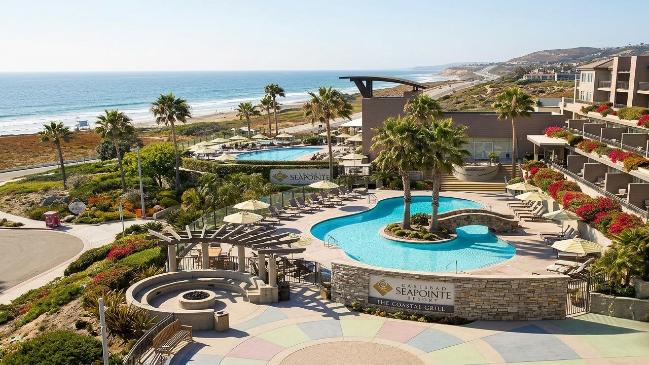 Poolside resort with palm trees, curved pool, sun loungers, and ocean view&mdash;lively courtyard, hotel balconies, and beach beyond.
