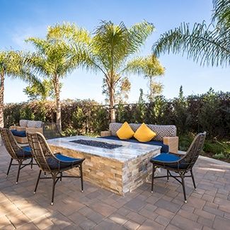 Beach scene with lounge chairs under palm trees, clear sky, and a sunny vibe.
