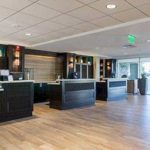 A modern, open-plan office with desks along the left and a seating area on the right, bright lighting, and glass walls&mdash;nice and airy.